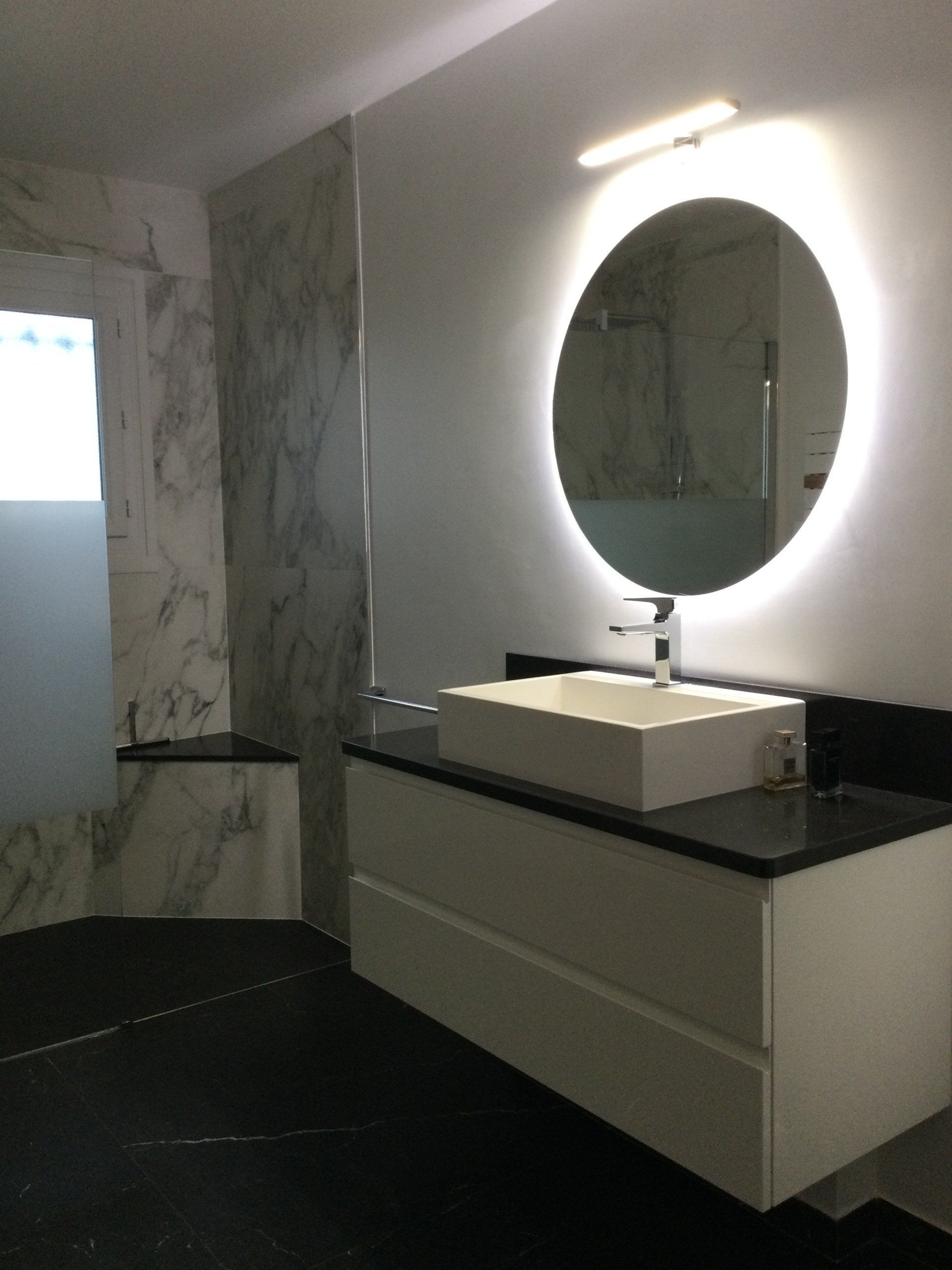 Meuble de salle de bains avec un miroir rond