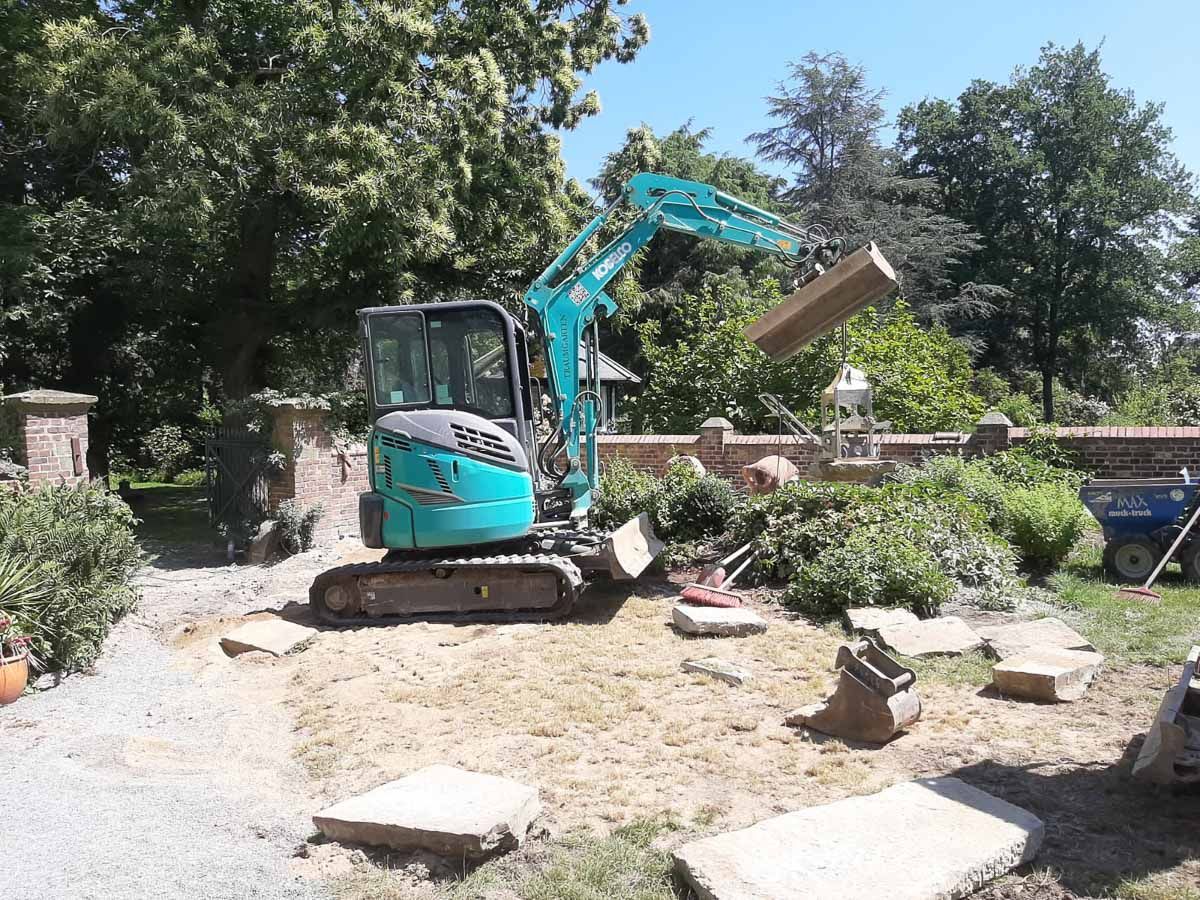 ein blauer und weißer Bagger , der in einem Garten arbeitet - Traumgärten Benjamin Biermeyer aus Soest