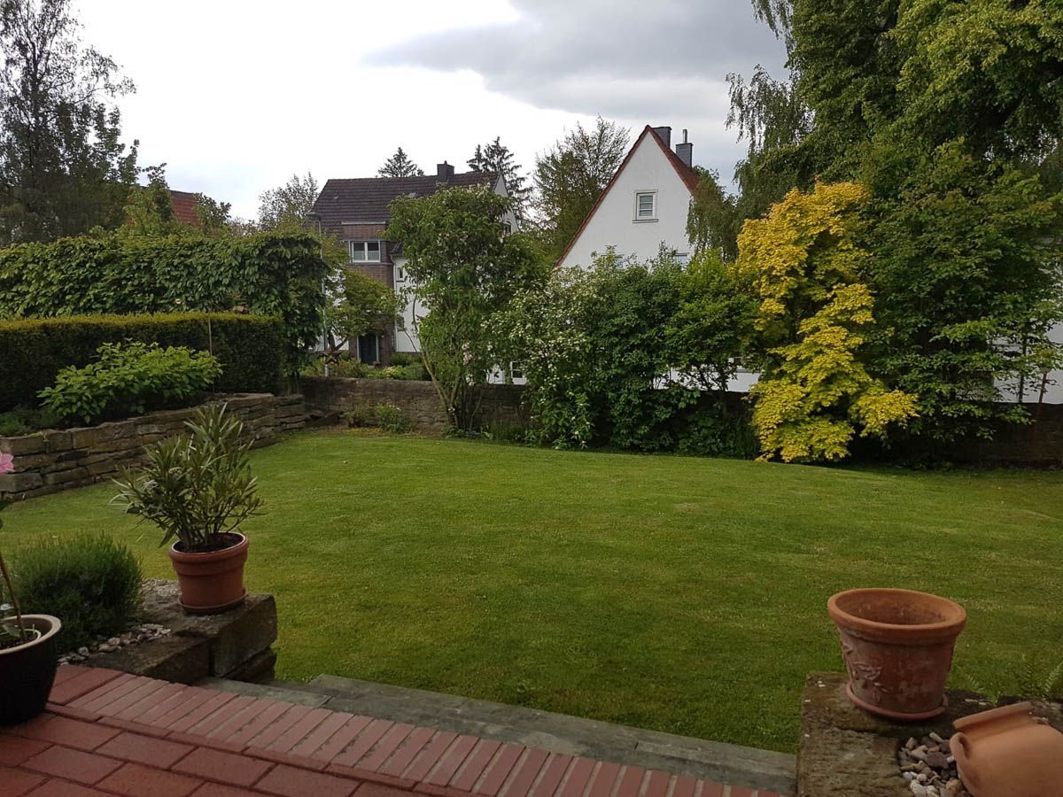 eine Terrasse mit Blick auf einen Rasen und ein Haus im Hintergrund -Traumgärten Benjamin Biermeyer aus Soest
