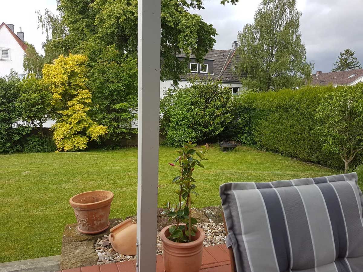 ein gestreifter Stuhl sitzt auf einer Terrasse mit Blick auf einen Garten - Traumgärten Benjamin Biermeyer aus Soest