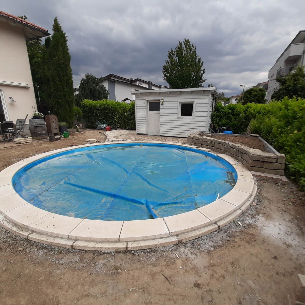 ein rundes Schwimmbad mit einer blauen Decke darauf - Traumgärten Benjamin Biermeyer aus Soest
