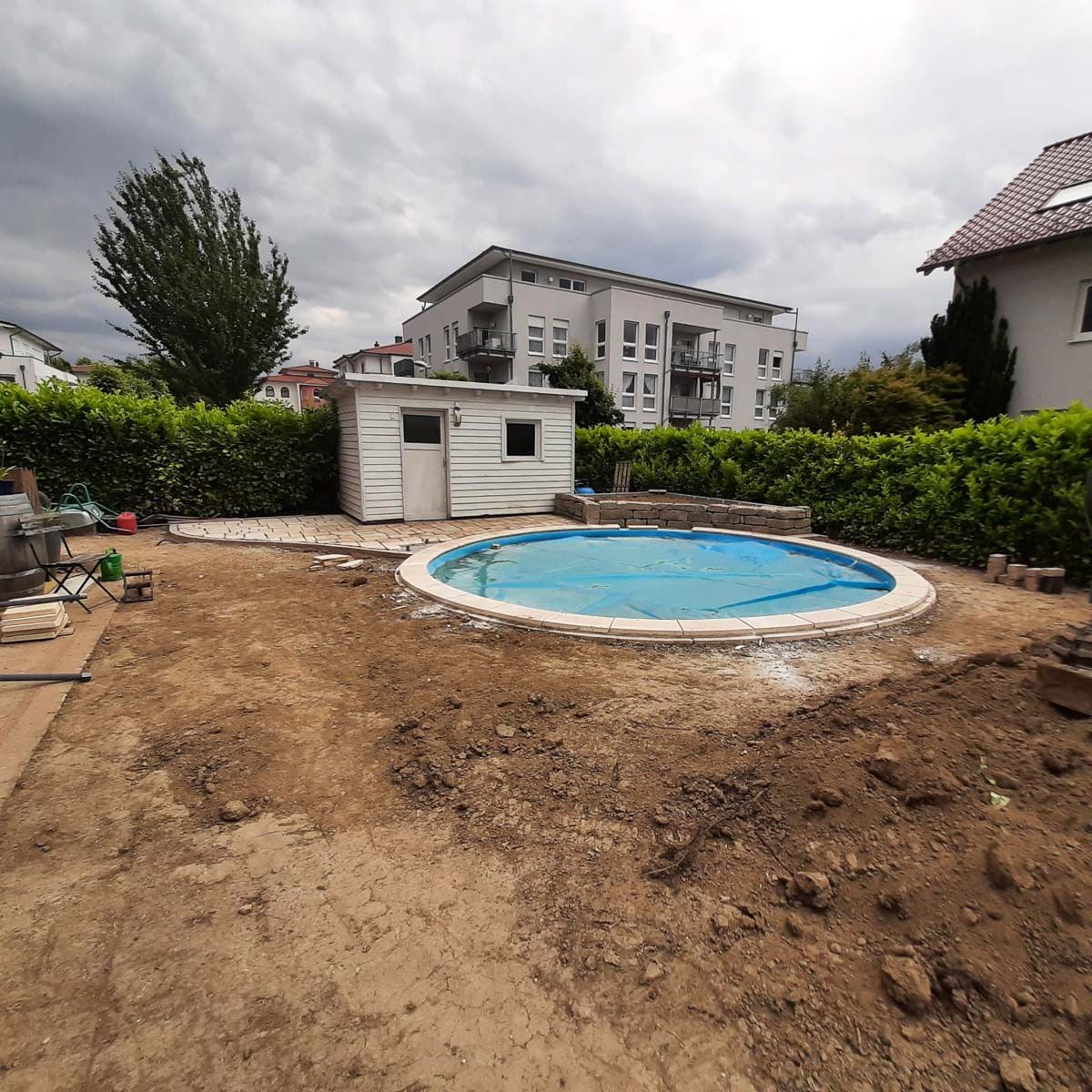 ein rundes Schwimmbad in einem Garten mit einem kleinen Gebäude im Hintergrund - Traumgärten Benjamin Biermeyer aus Soest