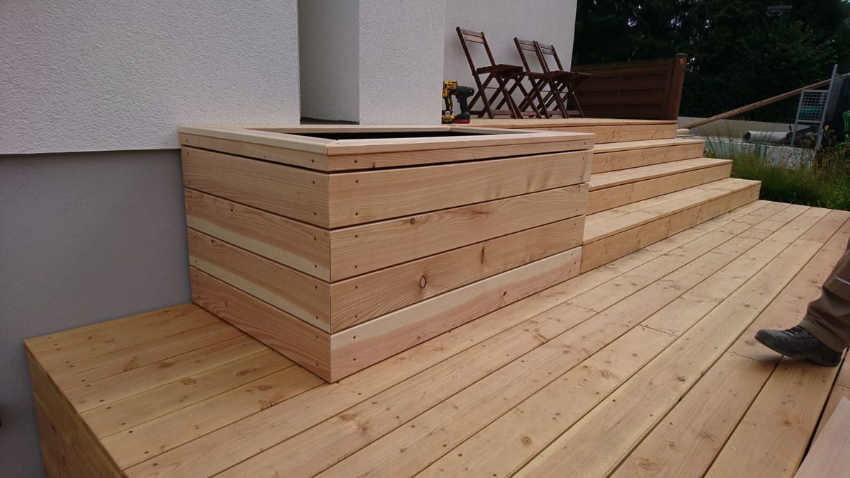 eine Person steht auf einem Holzdeck mit einer Holzkiste darauf - Traumgärten Benjamin Biermeyer aus Soest