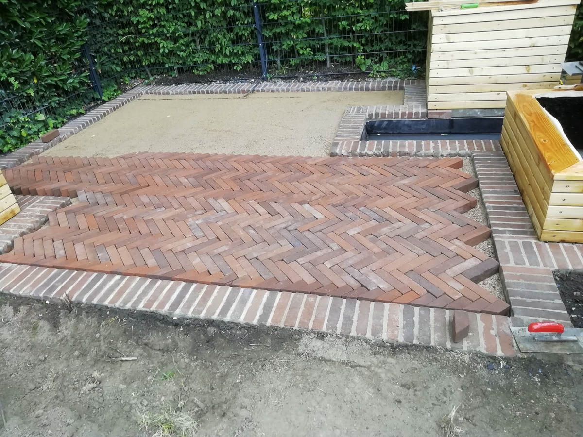 ein Backsteinpflaster mit einem Ziegelmuster und einem Holzkübel darauf - Traumgärten Benjamin Biermeyer aus Soest