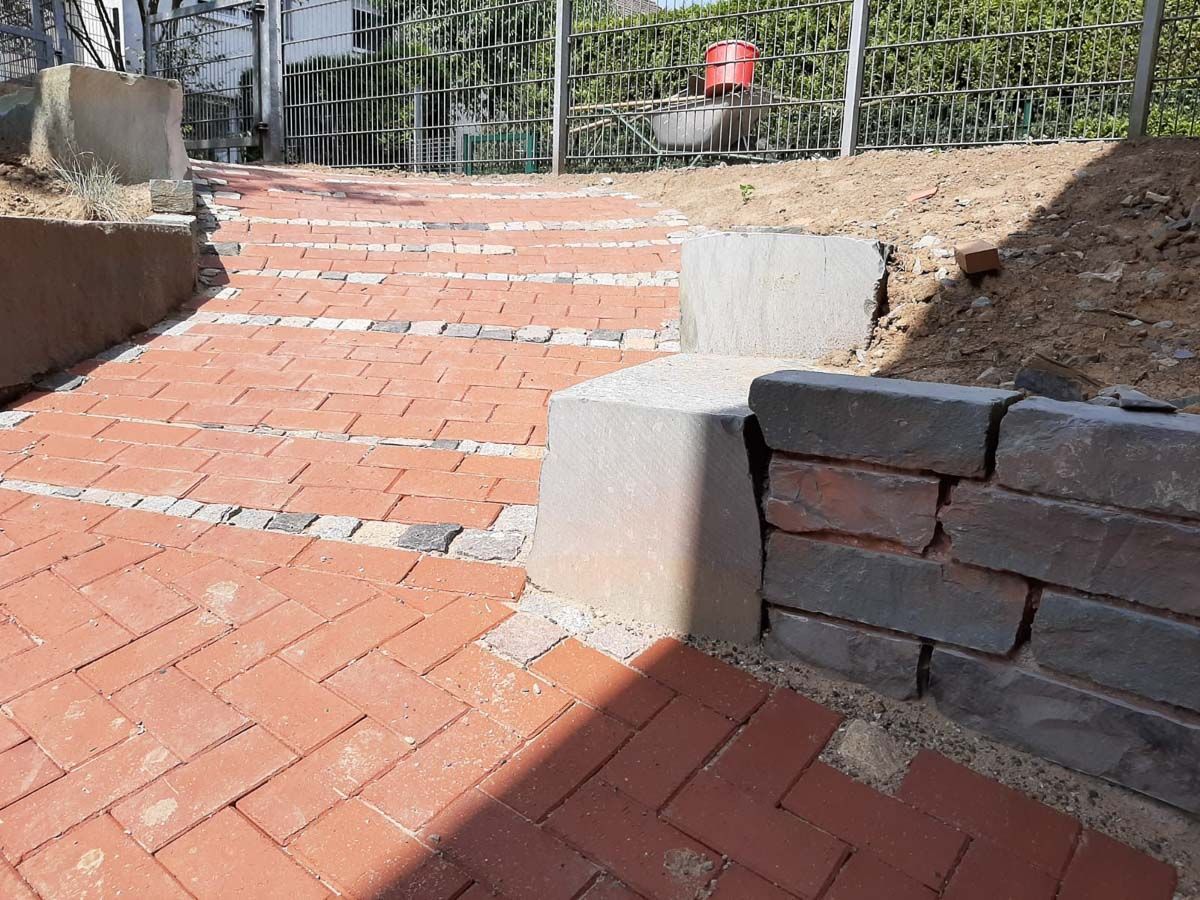 ein Gehweg aus Backsteinen mit einem Zaun im Hintergrund - Traumgärten Benjamin Biermeyer aus Soest