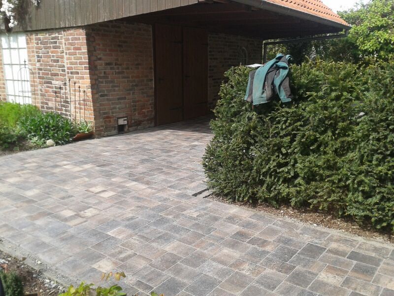 ein Parkplatz vor einem Backsteinhaus mit einem Zaun davor - Traumgärten Benjamin Biermeyer aus Soest