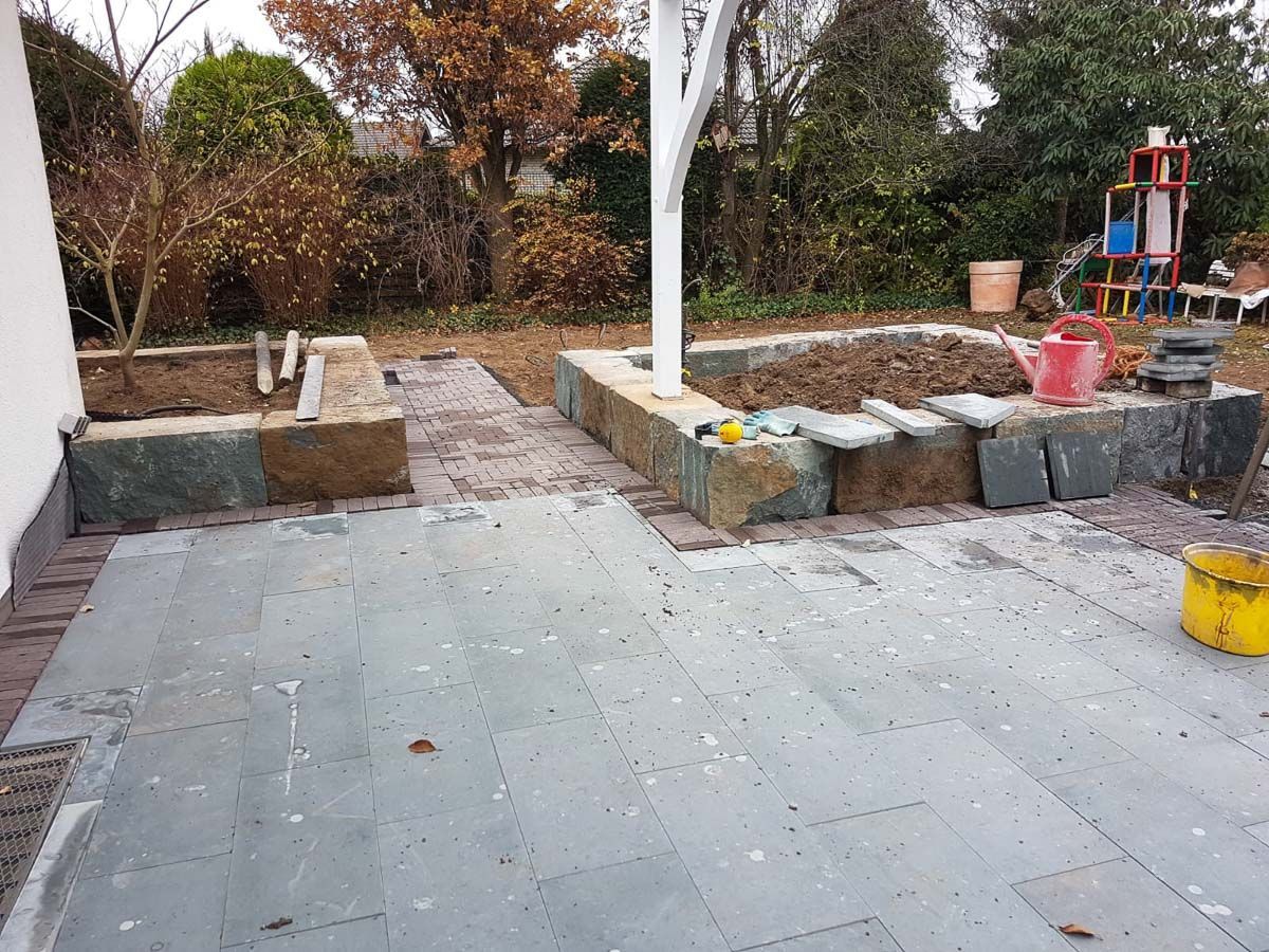 ein kleiner patio mit einem gelben Eimer auf dem Boden - Traumgärten Benjamin Biermeyer aus Soest