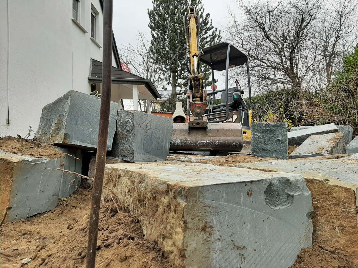 ein Bagger , der neben einem großen Stein steht - Traumgärten Benjamin Biermeyer aus Soest