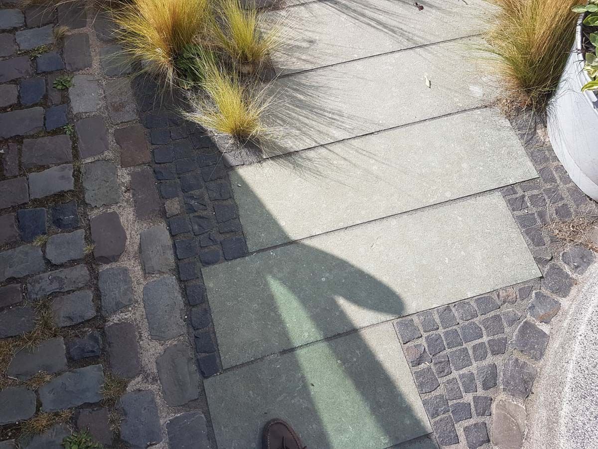 eine Person steht auf einem Bürgersteig mit einem Schatten auf dem Bürgersteig - Traumgärten Benjamin Biermeyer aus Soest