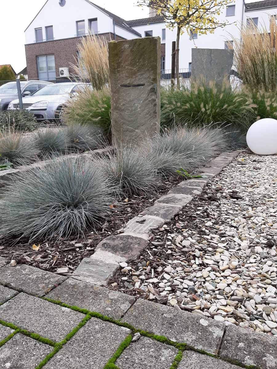 ein Garten mit Steinen , Gras und einer weißen Kugel - Traumgärten Benjamin Biermeyer aus Soest