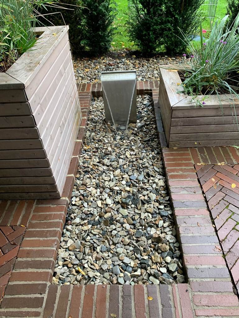 ein Brunnen in einem Garten mit Steinen und Backsteinen - Traumgärten Benjamin Biermeyer aus Soest