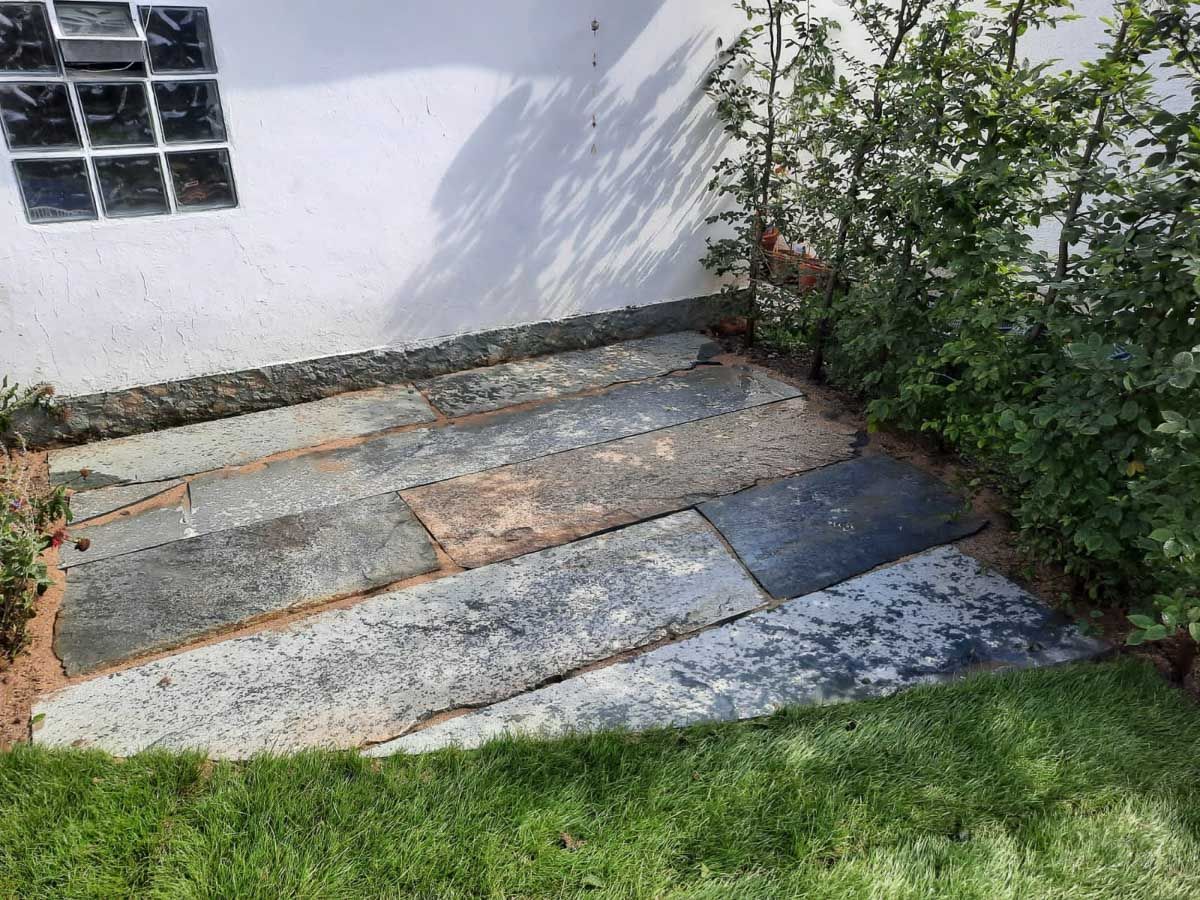 eine Reihe von Steinen , die neben einem weißen Gebäude stehen - Traumgärten Benjamin Biermeyer aus Soest