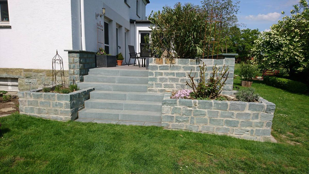 ein weißes Haus mit einer Steinmauer und einer Treppe davor - Traumgärten Benjamin Biermeyer aus Soest