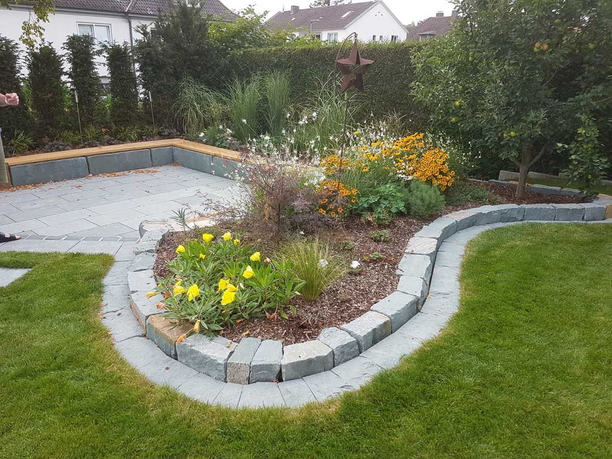 ein Garten mit einem Kreis aus Steinen und gelben Blumen - Traumgärten Benjamin Biermeyer aus Soest