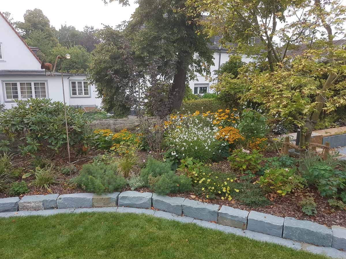 ein Garten mit Gras und Blumen und einem Haus im Hintergrund - Traumgärten Benjamin Biermeyer aus Soest