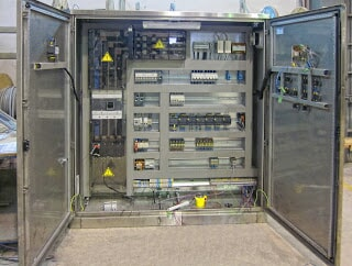Uma grande caixa elétrica com as portas abertas e muitos fios saindo dela.