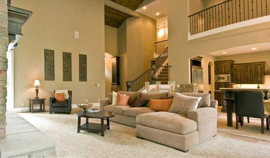 Una sala de estar con sofá, sillas, mesa de café y escaleras.