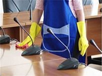 Una mujer está limpiando micrófonos en una sala de conferencias.