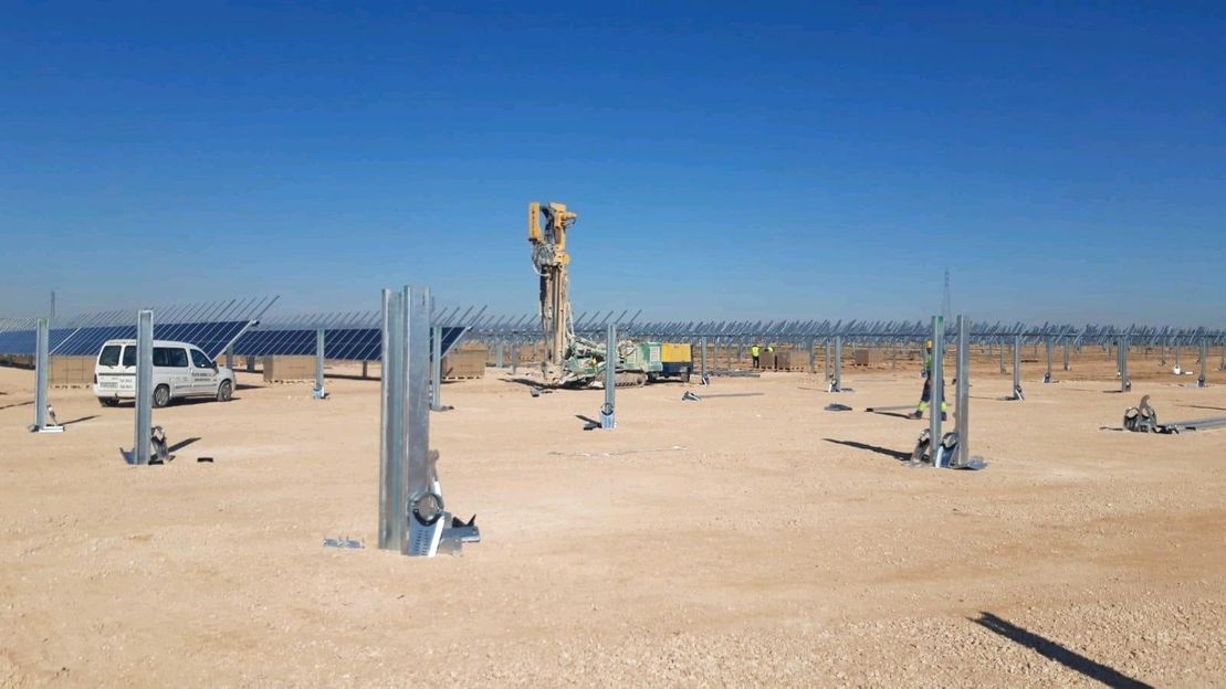 Un hombre está trabajando en una granja solar en el desierto.