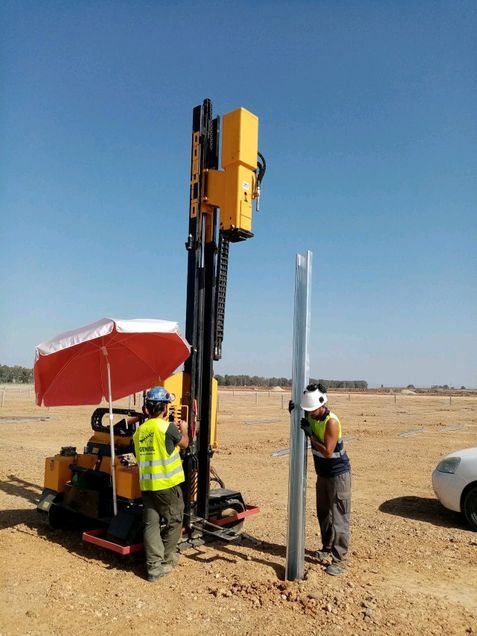 Dos hombres están trabajando en una máquina en un campo.