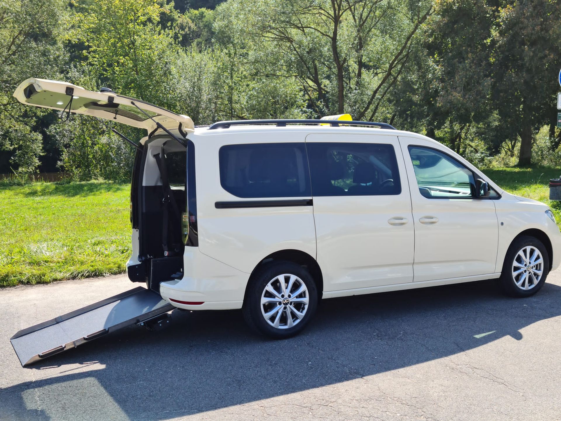 Mitarbeiter von Taxi Wein beim Transport einer älteren Dame im Rollstuhl