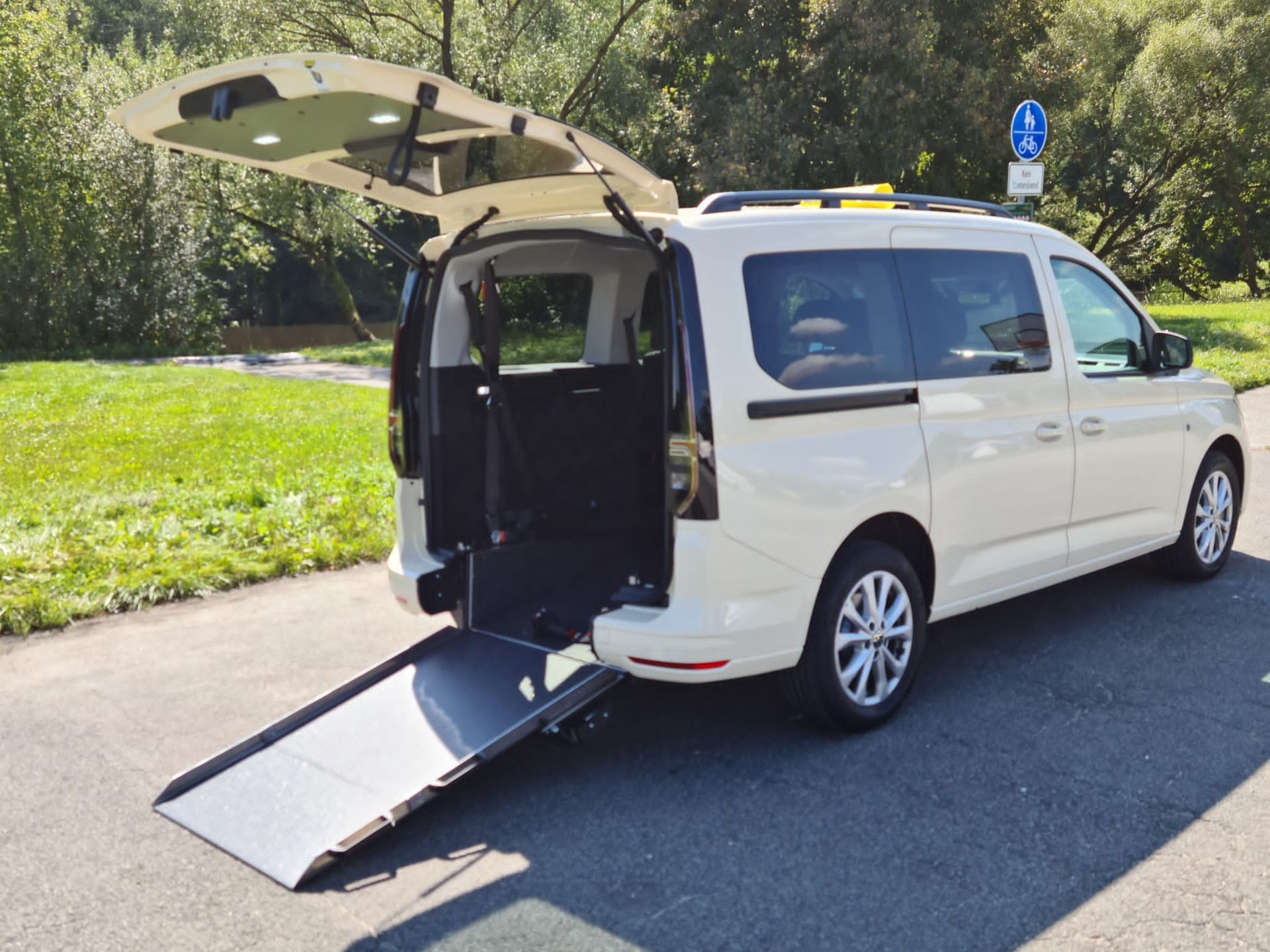 Rollstuhlfahrer benutzt die Rollstuhlrampe, um in ein Taxi von Taxi Wein einzusteigen