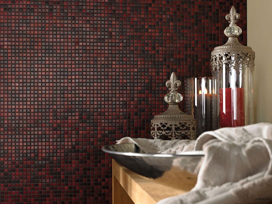 Ein Badezimmer mit einer roten Mosaikwand und einem Waschbecken und Kerzen