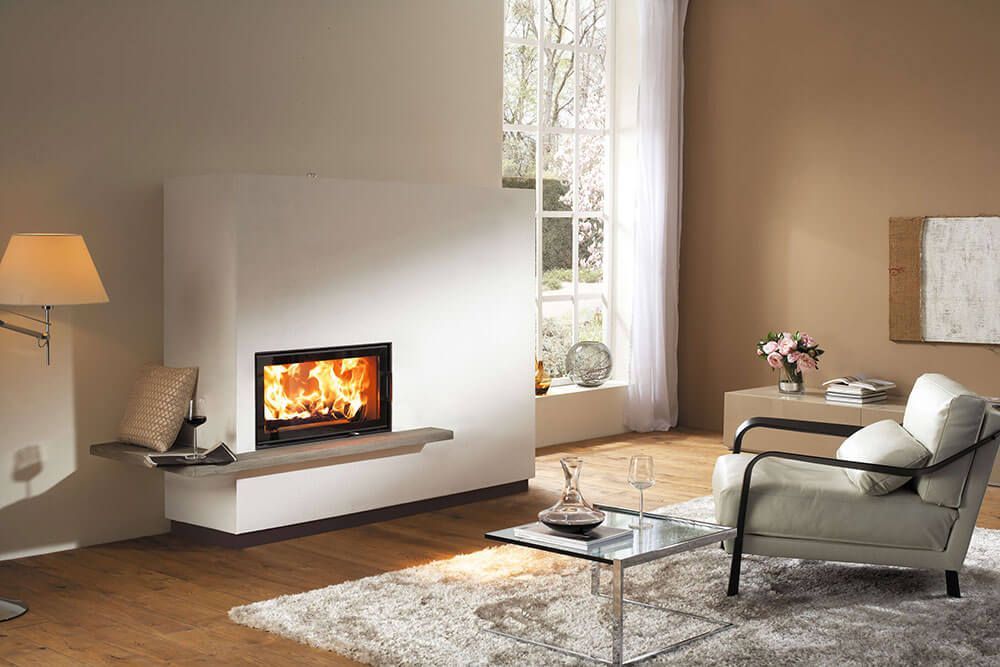 Ein Wohnzimmer mit Kamin, Stuhl, Tisch und Lampe.