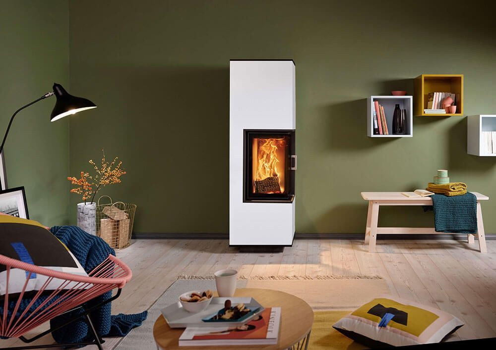 Ein Wohnzimmer mit grünen Wänden und einem weißen Kamin.