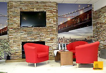 Ein Wohnzimmer mit zwei roten Stühlen und einem Flachbildfernseher