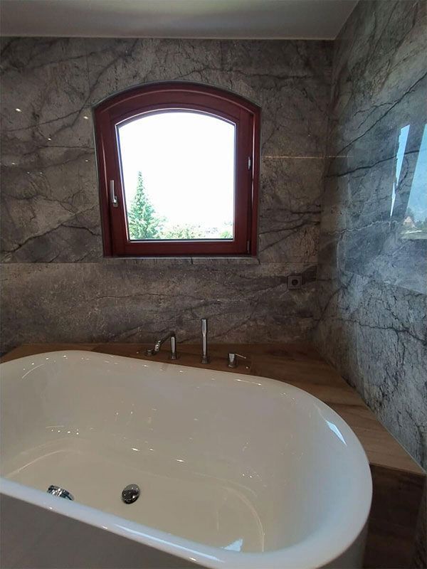 Ein Badezimmer mit Badewanne und Fenster.