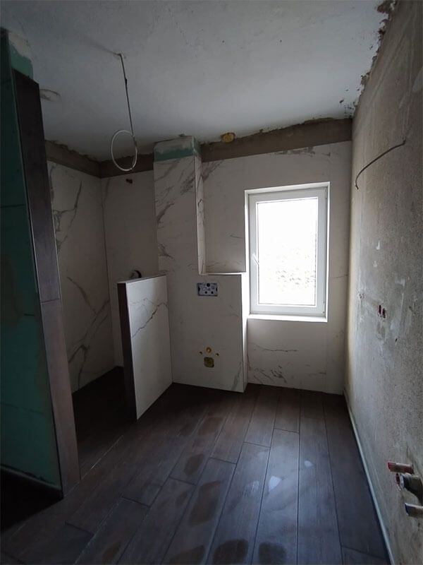 Ein leerer Raum mit Hartholzböden und einem Fenster