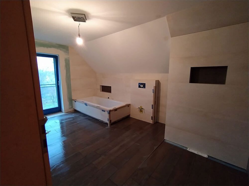 Ein im Bau befindliches Badezimmer mit Badewanne und Fenster.