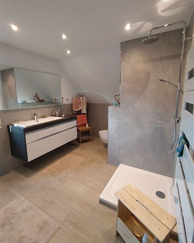 Ein Badezimmer mit zwei Waschbecken, einer Toilette, einer Dusche und einem Spiegel.