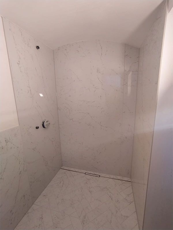 Ein Badezimmer mit ebenerdiger Dusche und Marmorboden.