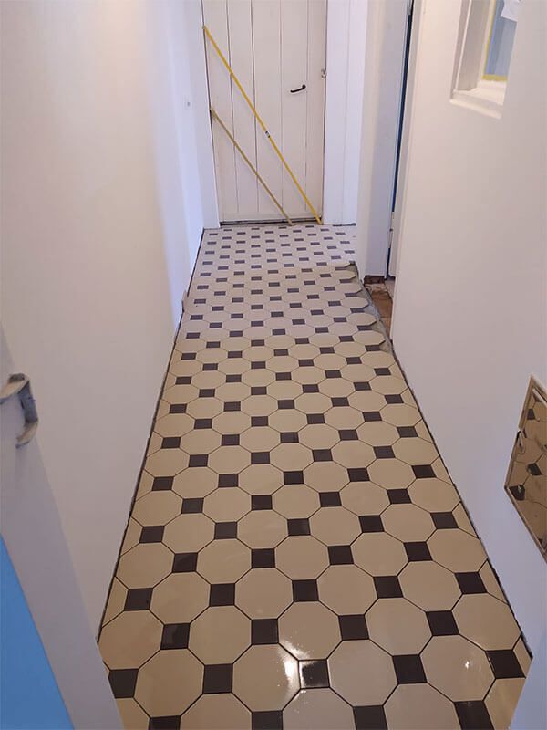 Ein Flur mit schwarz-weiß kariertem Boden