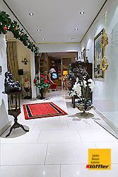 Ein Flur in einem Haus, das für Weihnachten mit einem roten Teppich und einer Laterne dekoriert ist.