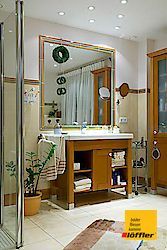 Ein Badezimmer mit großem Spiegel und Waschbecken.