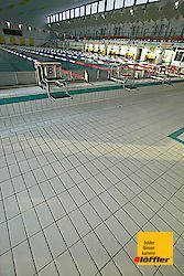 Ein großes Hallenbad mit gefliestem Boden.