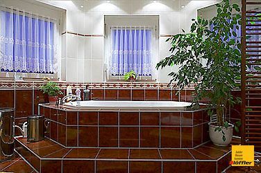 Ein Badezimmer mit einer großen Badewanne und einer Pflanze