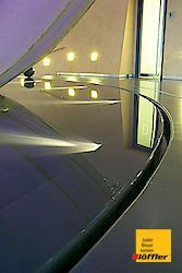 Eine Nahaufnahme eines gebogenen Glastisches in einem Raum.