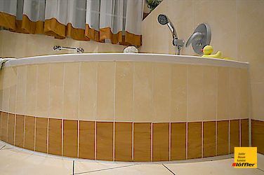 Ein Badezimmer mit Badewanne und Duschkopf.