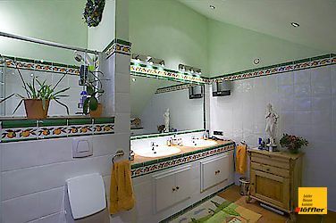 Ein Badezimmer mit zwei Waschbecken, einem Spiegel und einer Kommode.