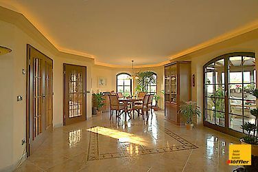 Ein großer Raum mit einem Esstisch und Stühlen