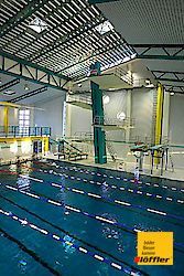 Ein großes Hallenbad mit Sprungbrett.