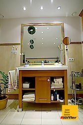 Ein Badezimmer mit Waschbecken, Spiegel und Handtüchern.