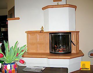 Ein Wohnzimmer mit Kamin und einer Blumenvase