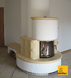 Ein runder Kamin mit einer Glastür in einem Wohnzimmer.