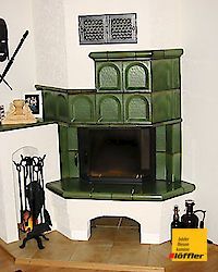 In der Ecke des Raumes steht ein grüner Kamin.