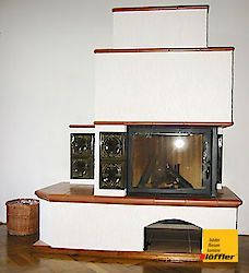 In einem Wohnzimmer steht auf einem Holzboden ein Kamin.